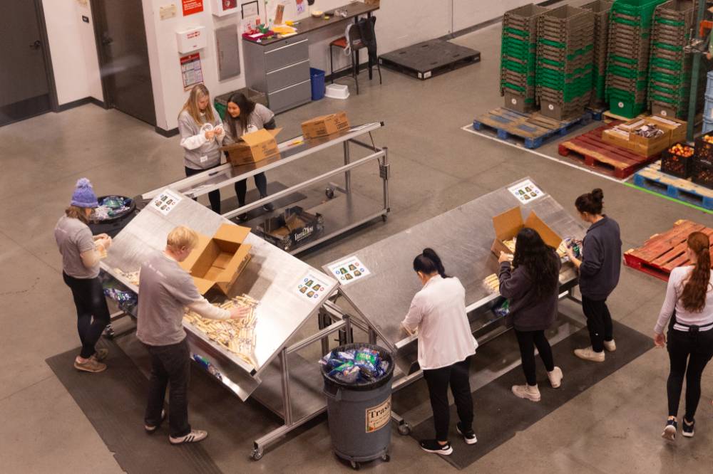 Birds eye view of students loading food into boxes